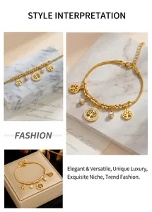Detail view of a gold-toned snake chain bracelet featuring tree of life charms and crystals