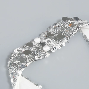Detail of white evening dress collar with sparkling silver sequins and fabric buttons