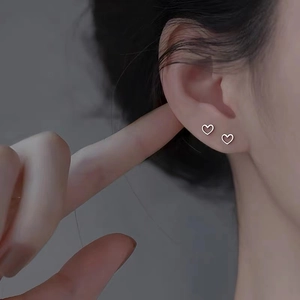 Eleganti orecchini a lobo a cuore in argento 925 indossati da una modella per un look premium
