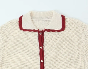 Detail of crochet polo top featuring cream knit texture and red scalloped edge trim