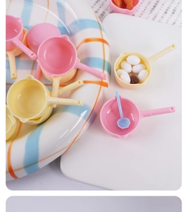 Detailed macro view of colorful miniature toy frying pans with tiny simulated eggs