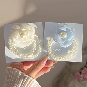 Elegant white and blue camellia flower hair ties with pearl bead bracelets on display cards