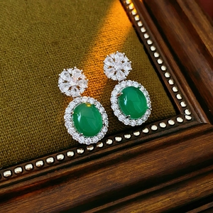 Détail de boucles d'oreilles vintage en calcédoine verte avec zircons sur velours