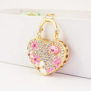 Golden heart keychain with white rhinestones and pink floral enamel details