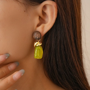 Close-up of vintage resin earrings featuring golden twisted metal and amber-toned drops