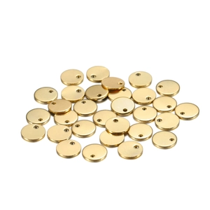 Close-up of DIY golden stainless steel round tags with small holes for jewelry making