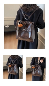 Detail of vintage brown leather backpack with plush bear charm and woven lanyard