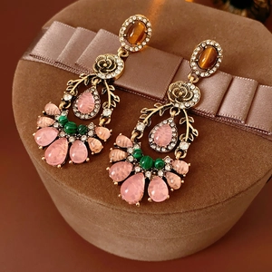 Detail of vintage flower earrings with colorful gems on a brown velvet jewelry box