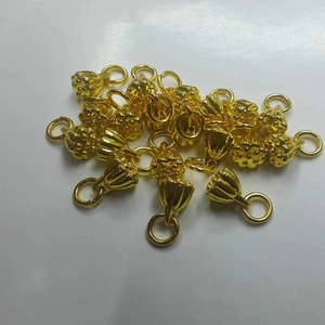Golden lotus seed pod charms made of durable metal for jewelry making on white background
