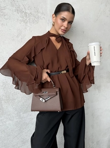 Detail of brown chiffon blouse featuring bow tie neck and ruffled bell sleeves