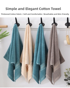 Close-up of four thick cotton towels in various colors hanging on a minimalist black rack