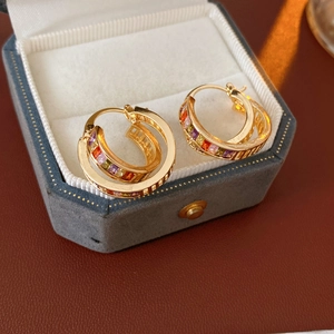 Detail of vintage gold hoop earrings with multi-colored crystals in a jewelry box