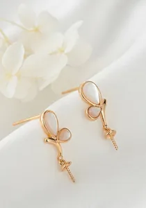 Vue détaillée de composants de boucles d'oreilles papillon dorés 14K avec nacre