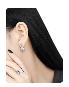 Detail of silver irregular lava texture earrings and wavy ring on a model