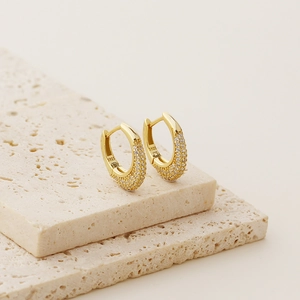 Detail of S925 sterling silver stamp on gold U-shaped earrings with pave zircon stones