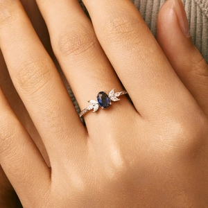 Elegant s925 silver ring featuring an oval blue sapphire and marquise zircon accents