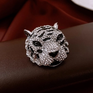Macro view of vintage tiger head brooch with silver metal, zircons and black enamel