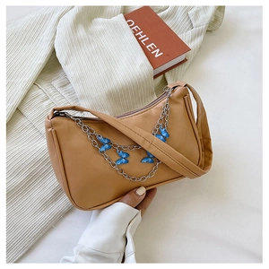 Detail of khaki PU leather shoulder bag with silver chain and blue butterfly charms
