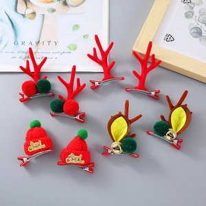 Weihnachts-Haarclips Set mit Rentiergeweih, rotem Hut und Glöckchen auf grauem Grund
