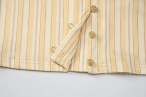 Détail macro du tissu à rayures jaunes et blanches avec boutons en résine et boucles