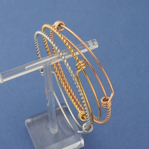 Detailed view of adjustable twisted cable bracelets in gold, silver, and rose gold finish