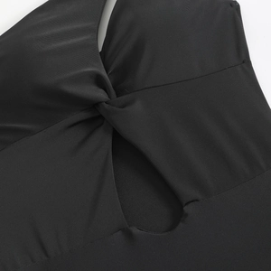 Detail of black one-shoulder swimsuit featuring a twist knot and diamond-shaped cutout design