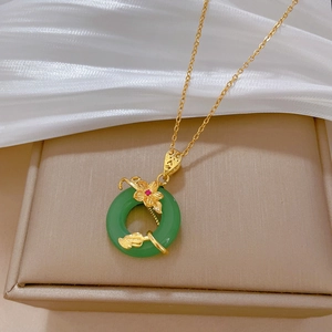Detail of flower jade pendant necklace with red gem on beige jewelry box and white silk