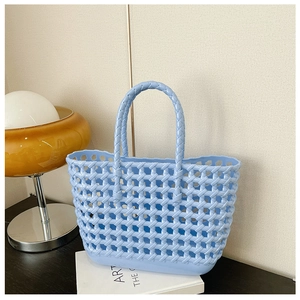Detail showing the woven hollow mesh texture of a light blue waterproof jelly basket bag