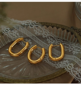 Detailed macro view of U-shaped gold plated earrings on a vintage lace tray