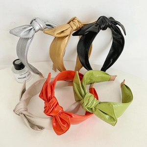 Detail of six colorful faux leather bow headbands showing texture and knotted design