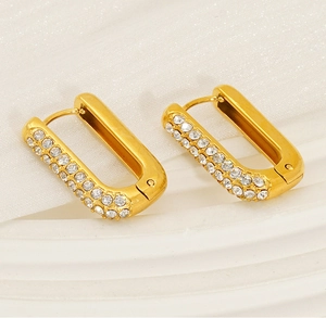 Macro detail of 18K gold plated hoop earrings featuring three rows of cubic zirconia crystals