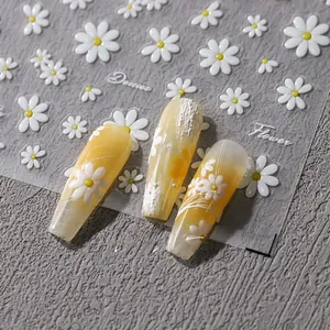 Macro shot of 3D white daisy nail art stickers TS-3595 on yellow glossy long nails