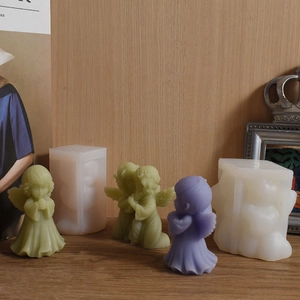 Detail view of angel shaped silicone mold with finished green and purple wax candles