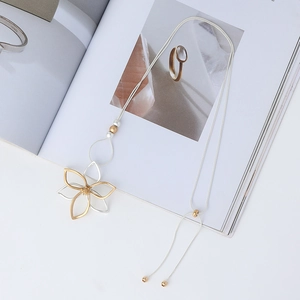 Detail of silver snake chain with layered gold flower pendant and adjustable slider clasp