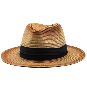 Detail of hand-woven straw fedora hat featuring brown gradient and black ribbon band