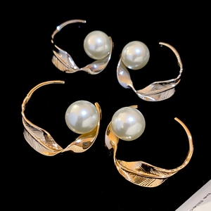 Dettaglio di eleganti orecchini a piuma intrecciata in oro e argento con perle