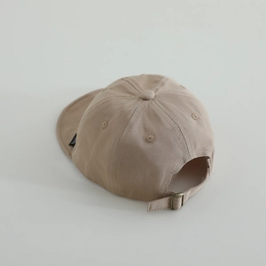 Détail de la casquette bébé en coton kaki avec boucle métallique et œillets d'aération