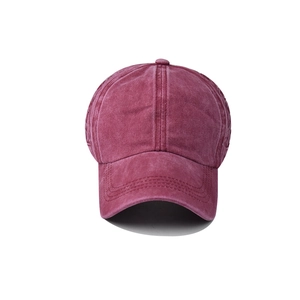 Detail of burgundy washed cotton baseball cap showing side braided stitching and vintage texture