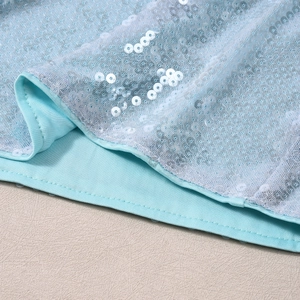 Gros plan détaillé de paillettes bleu ciel et des coutures de finition sur un haut ajusté