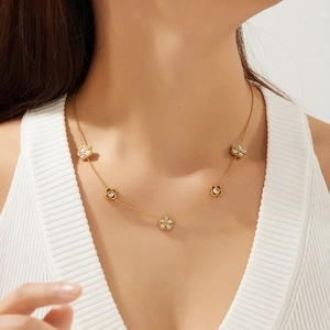 Close-up of gold plated stainless steel necklace with sparkling crystal flower pendants