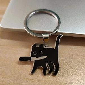 Close-up of a stainless steel black cat keychain with a knife, enamel cartoon design