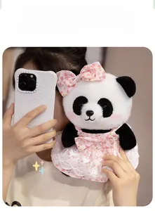 Detail of plush panda toy with pink floral bow and lace dress held by a model