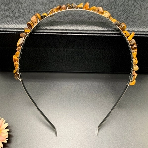Detailed view of handmade tiger eye crystal stones hand-wired on a black metal crown headband