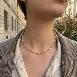 Elegant French style freshwater pearl and gold bead necklace worn with a tweed jacket