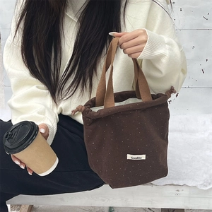 Close-up of wool polka dot drawstring bucket bag with Sozakka label and cord detail