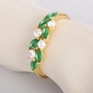 Detail of gold vine ring with green marquise gems and white diamonds on silk roll