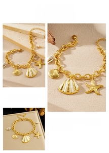 Detailed view of gold starfish and shell charms on a high-quality stainless steel bracelet