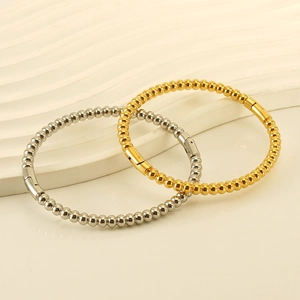 Minimalist stainless steel bead bracelets in gold and silver finish on textured display