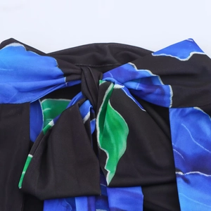 Macro view of blue and green floral print on dress with a stylish knot detail