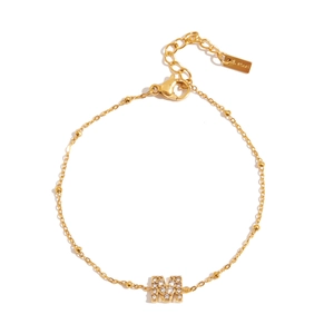 Detail of gold-plated stainless steel bracelet featuring zircon-encrusted letter M pendant